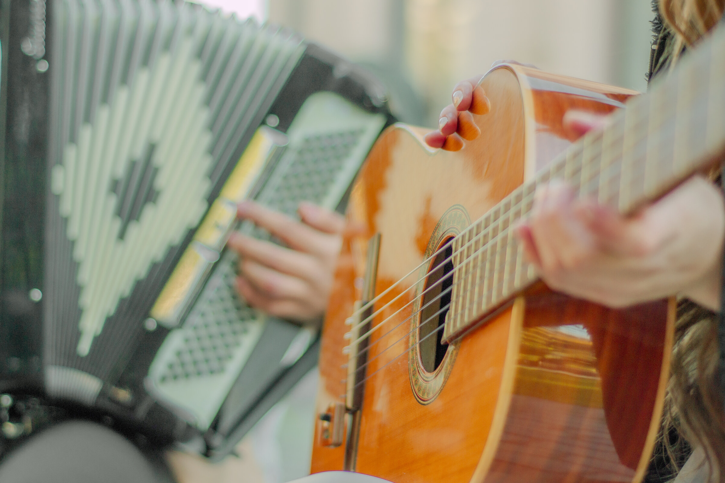 Detalle de las manos del Dúo Amores de Chile tocando acordeón y guitarra acústica con pasión.
