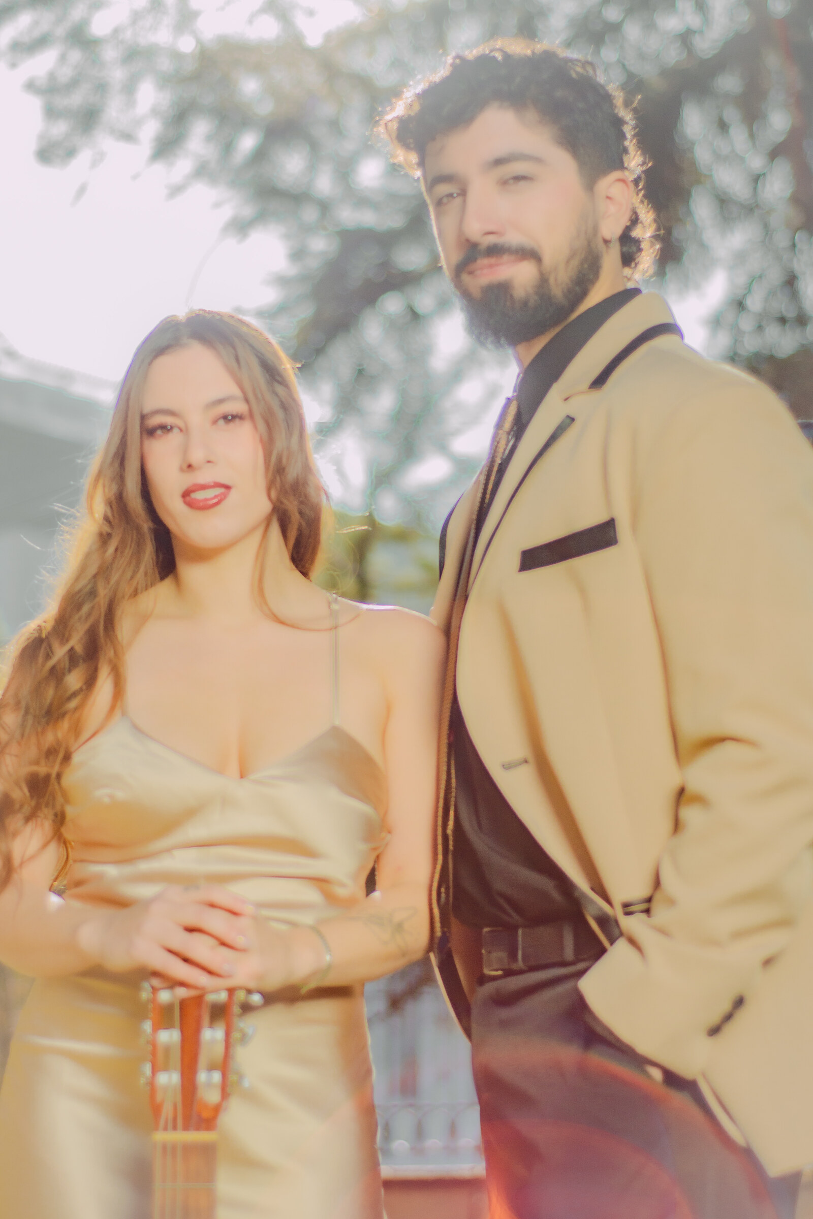 Dúo Amores de Chile en un retrato íntimo, ella con guitarra, él con acordeón, con luz suave en Palacio Cousiño.